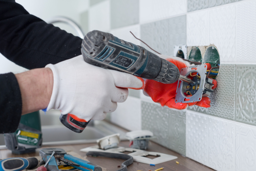 Electrician repairing home wiring outlet